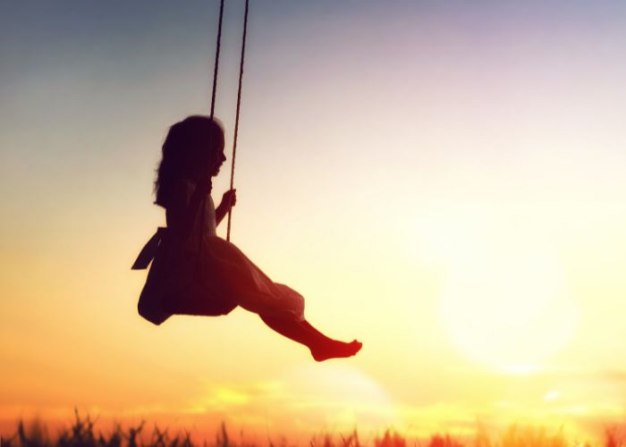 Vitamin D für Kinder: Mädchen schaukelt in der Sonne