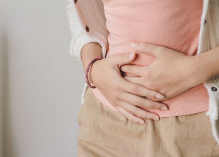 Frau hält sich schmerzhaften Blähbauch