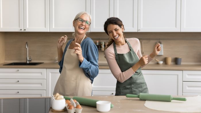 Menopause - Wechseljahre: zwei glueckliche Frauen in der Kueche