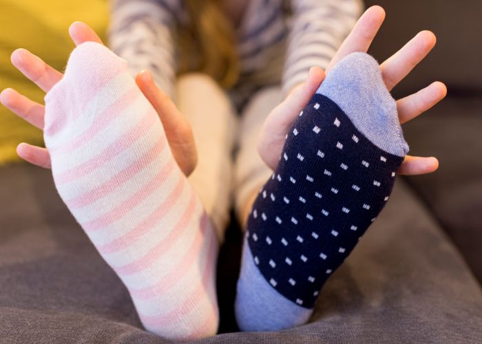 Frau hält Schweißfüße von sich weg